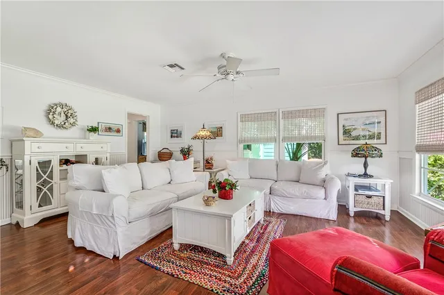 a living room with furniture a chandelier and a flat screen tv