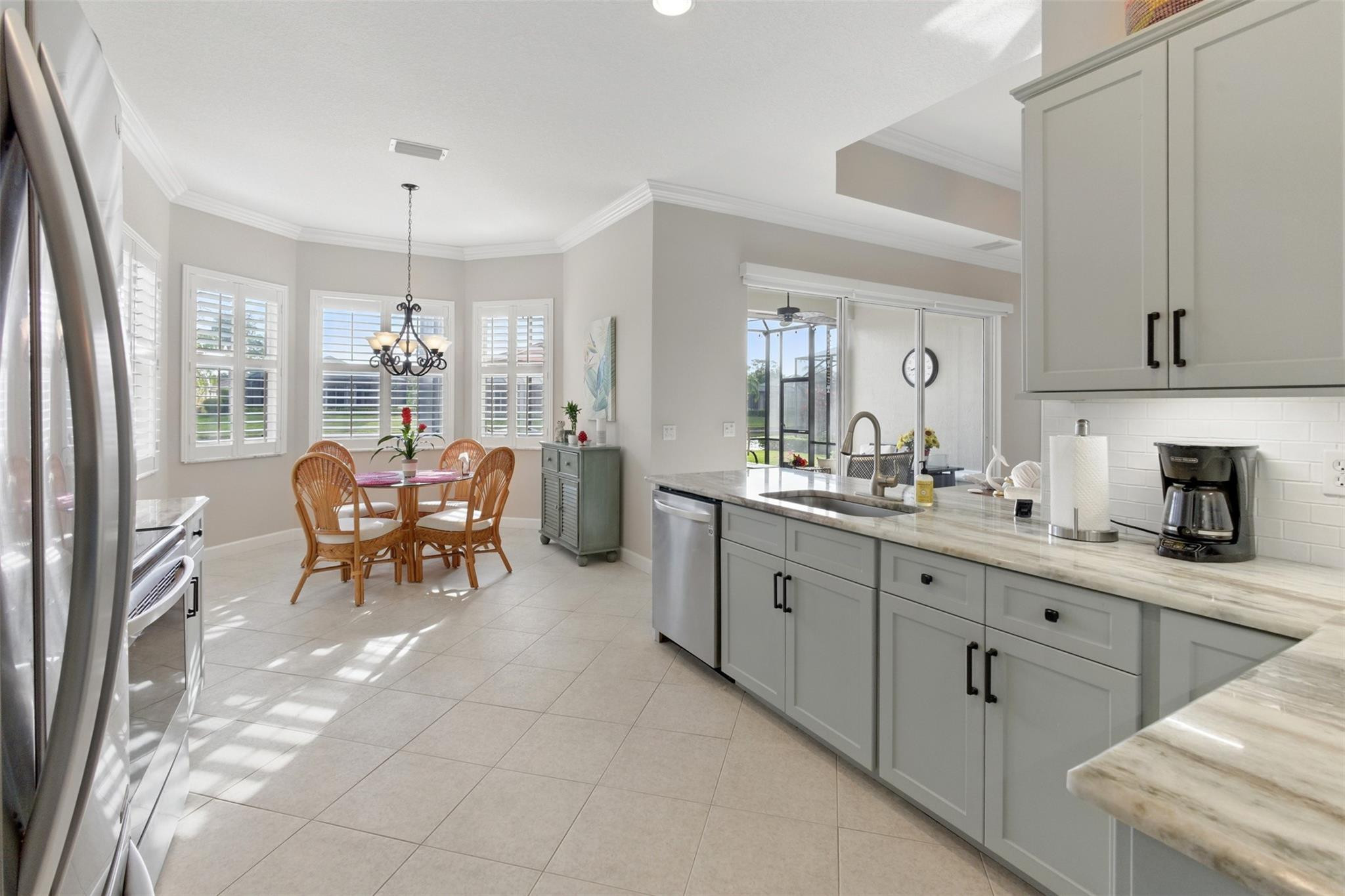 8836 First Tee Road Port St. Lucie, FL 34986 - Photo 11 of 35 a large white kitchen with cabinets and chairs