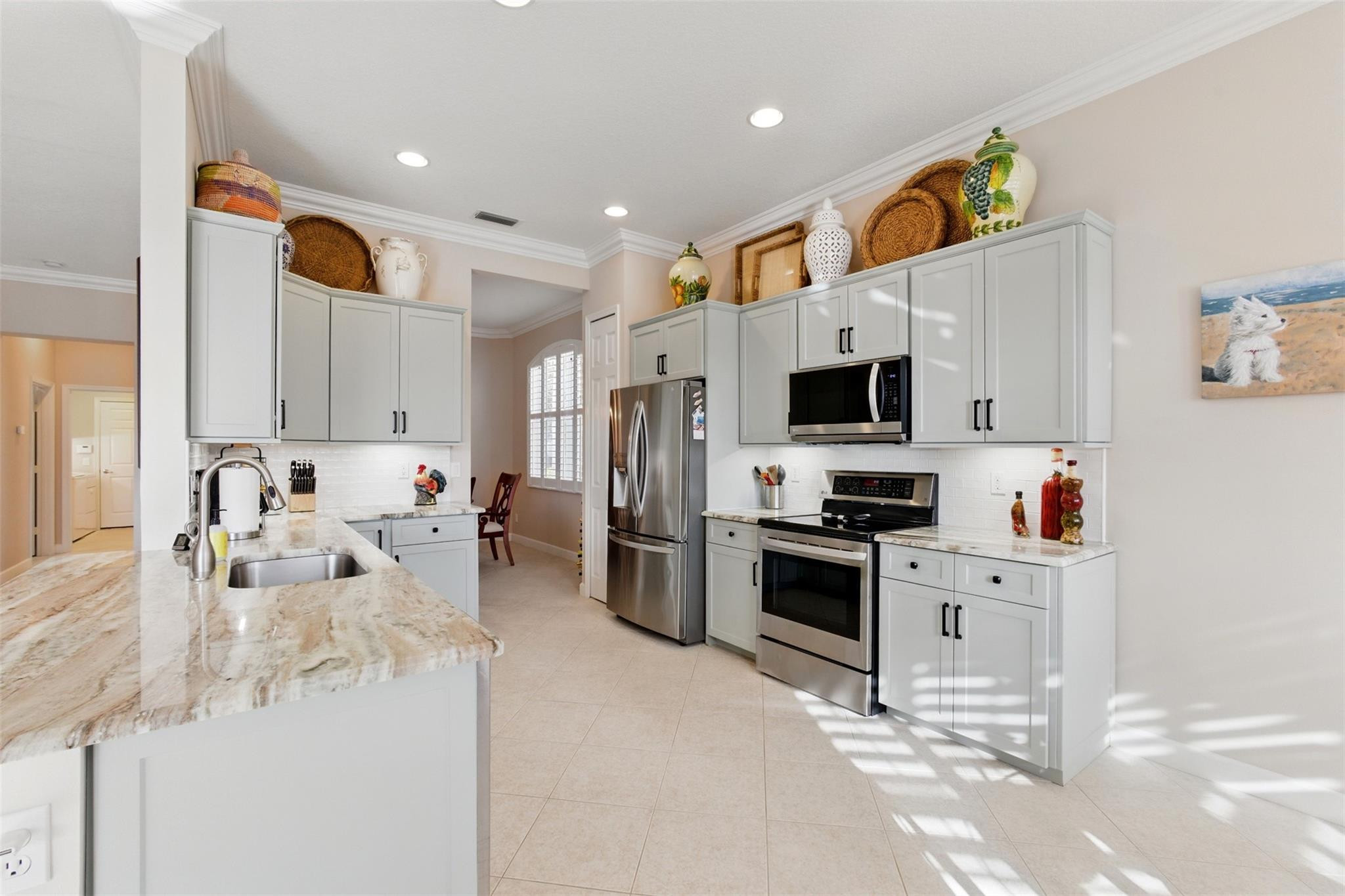 8836 First Tee Road Port St. Lucie, FL 34986 - Photo 10 of 35 a large white kitchen with stainless steel appliances