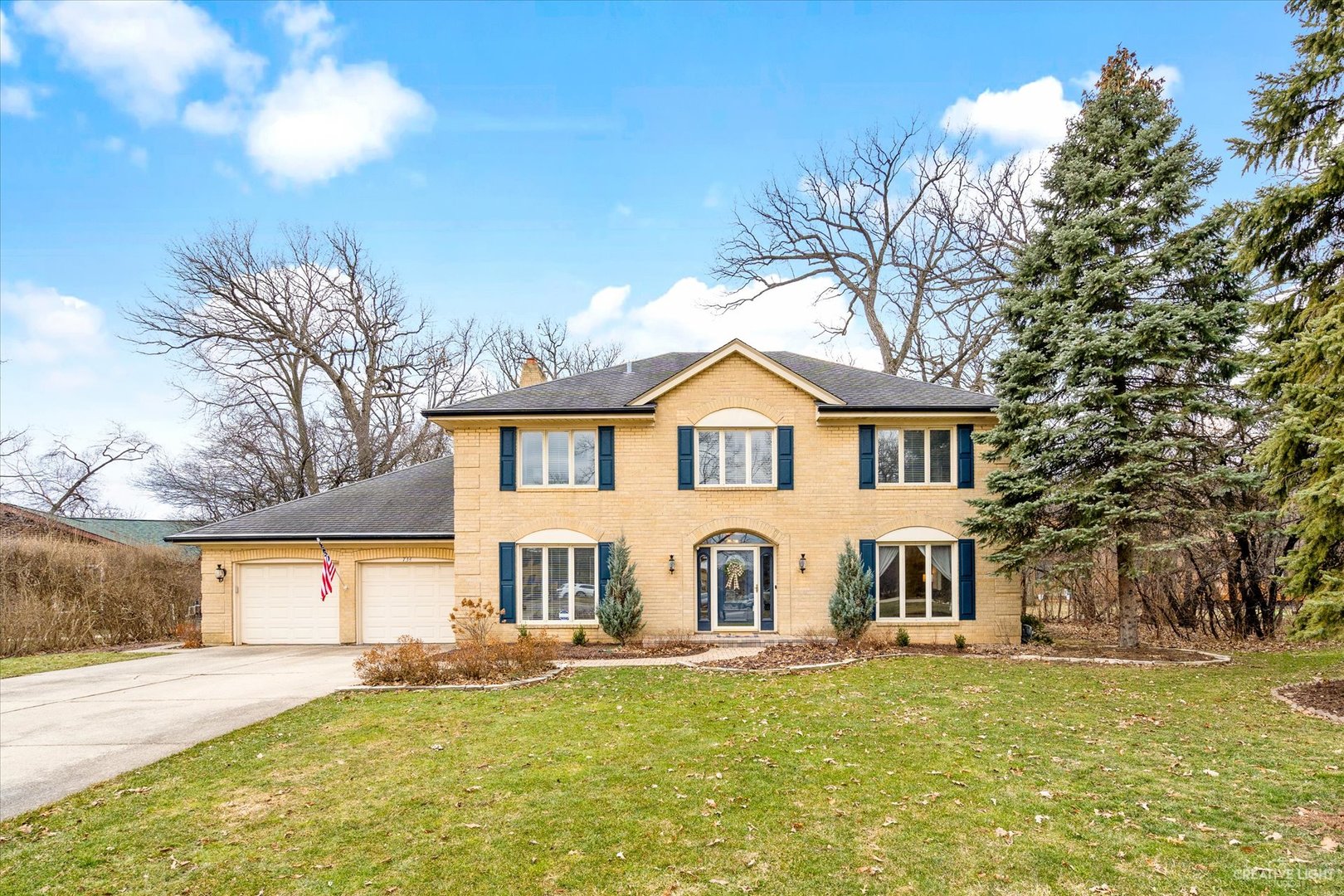 a view of a white house with a yard and a large tree