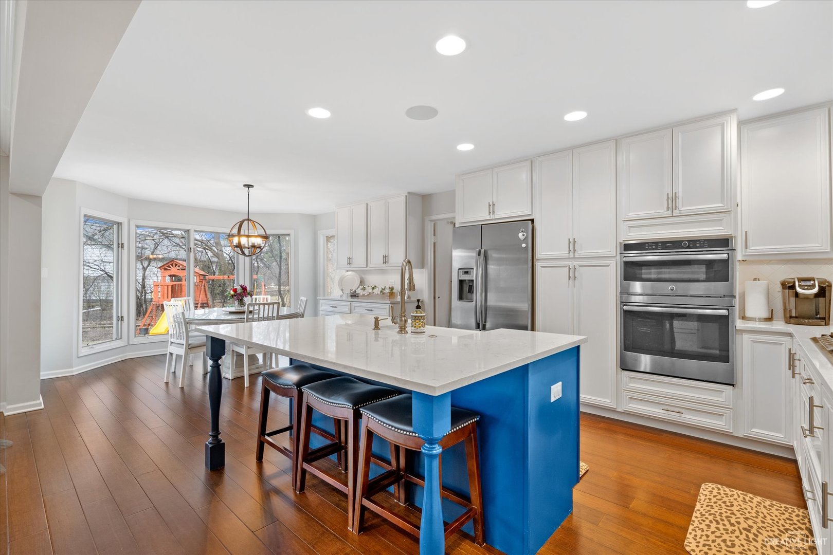 734 Forest Glen Lane Oak Brook, IL 60523 - Photo 17 of 36 a kitchen with stainless steel appliances granite countertop a table chairs stove and refrigerator