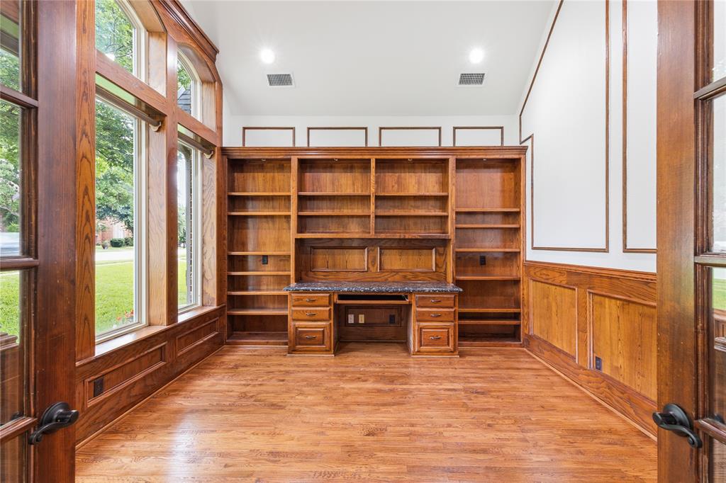 967 East Bethel School Road Coppell, TX 75019 - Photo 8 of 39 Dedicated space featuring extensive built-in cabinetry, an integrated desk with a dark countertop, and warm wood-finish flooring