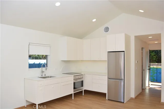 a kitchen with kitchen island a sink stainless steel appliances and cabinets
