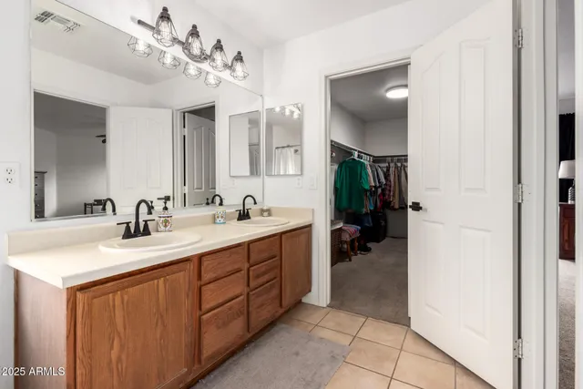 a en suite bathroom with a double vanity sink and a mirror