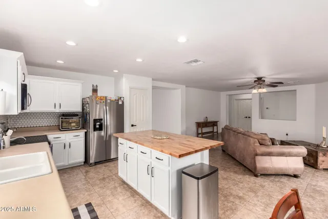 a open kitchen with stainless steel appliances kitchen island granite countertop a refrigerator and a stove top oven