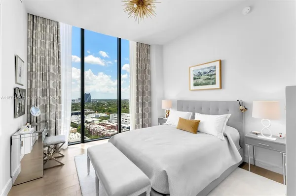a bedroom with a bed and a large window