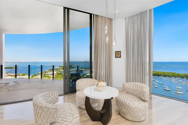 a living room with furniture and a floor to ceiling window
