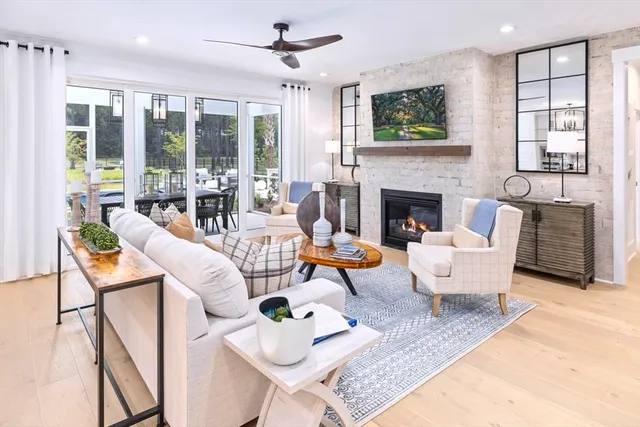 a living room with furniture a fireplace and a floor to ceiling window