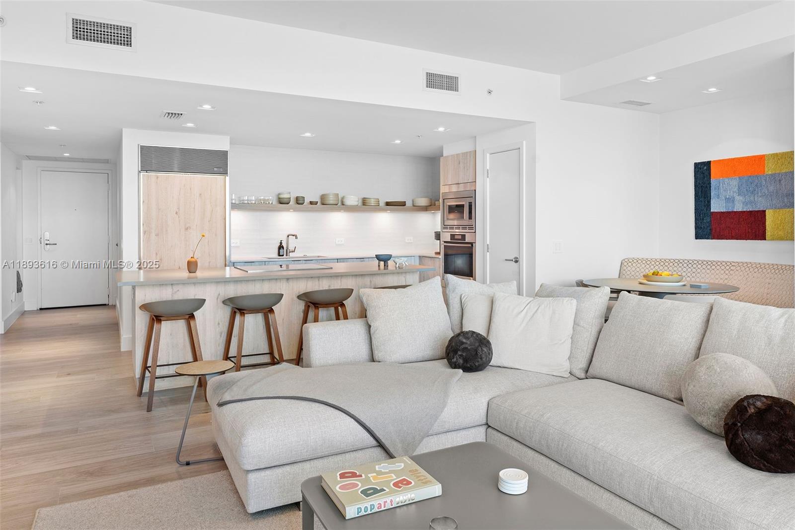 6899 Collins Avenue, Unit 2601 Miami Beach, FL 33141 - Photo 14 of 70 a living room with furniture and a dining table with wooden floor