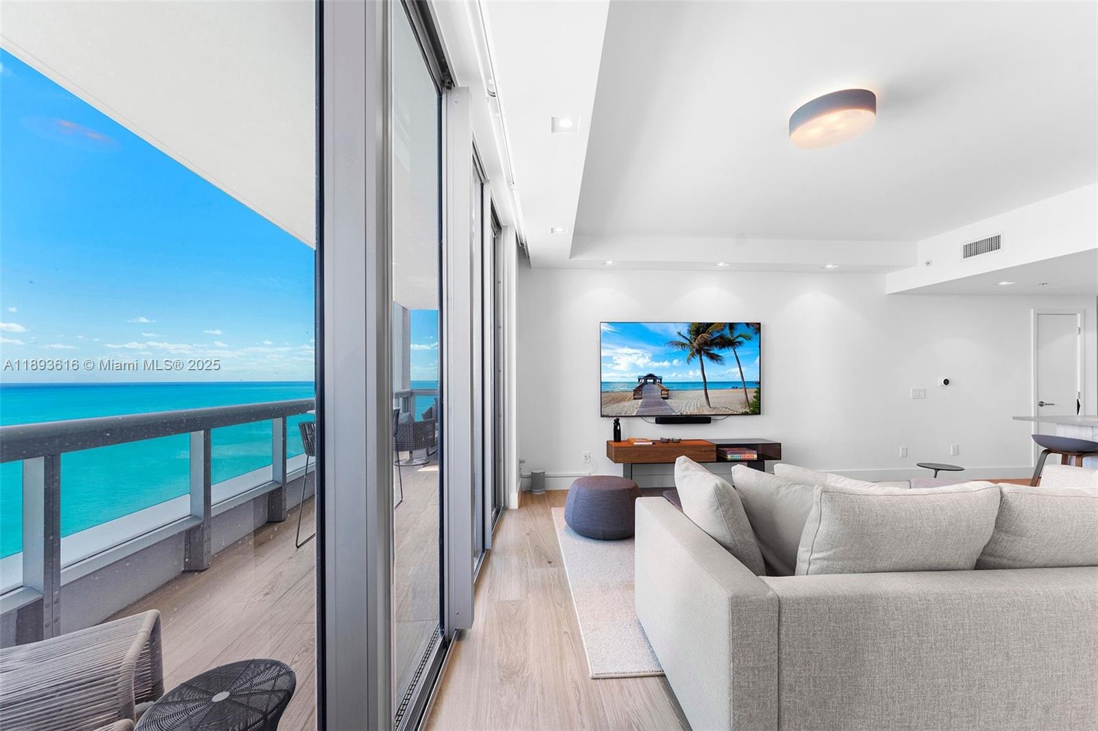 6899 Collins Avenue, Unit 2601 Miami Beach, FL 33141 - Photo 19 of 70 a living room with furniture and a flat screen tv