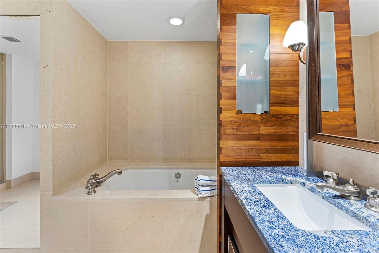 6899 Collins Avenue, Unit 2601 Miami Beach, FL 33141 - Photo 21 of 70 a bathroom with a granite countertop tub sink and mirror