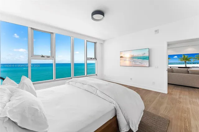 a spacious bedroom with a bed and a large window