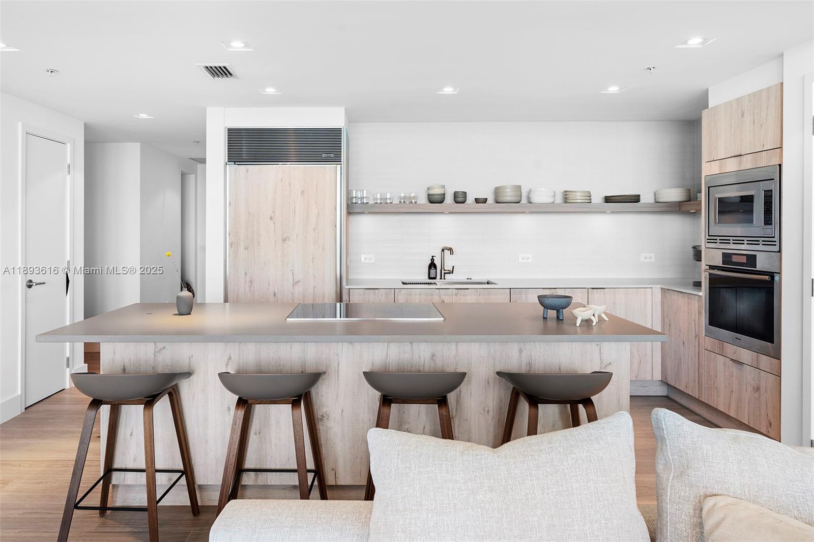 6899 Collins Avenue, Unit 2601 Miami Beach, FL 33141 - Photo 27 of 70 a kitchen with stainless steel appliances kitchen island granite countertop a table and chairs in it