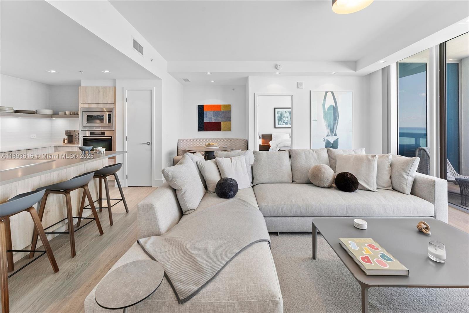 6899 Collins Avenue, Unit 2601 Miami Beach, FL 33141 - Photo 10 of 70 a living room with furniture and a view of kitchen