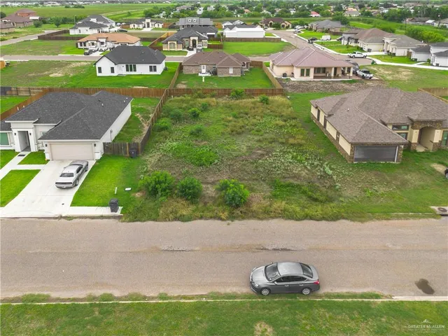 an aerial view of residential houses with outdoor space and swimming pool