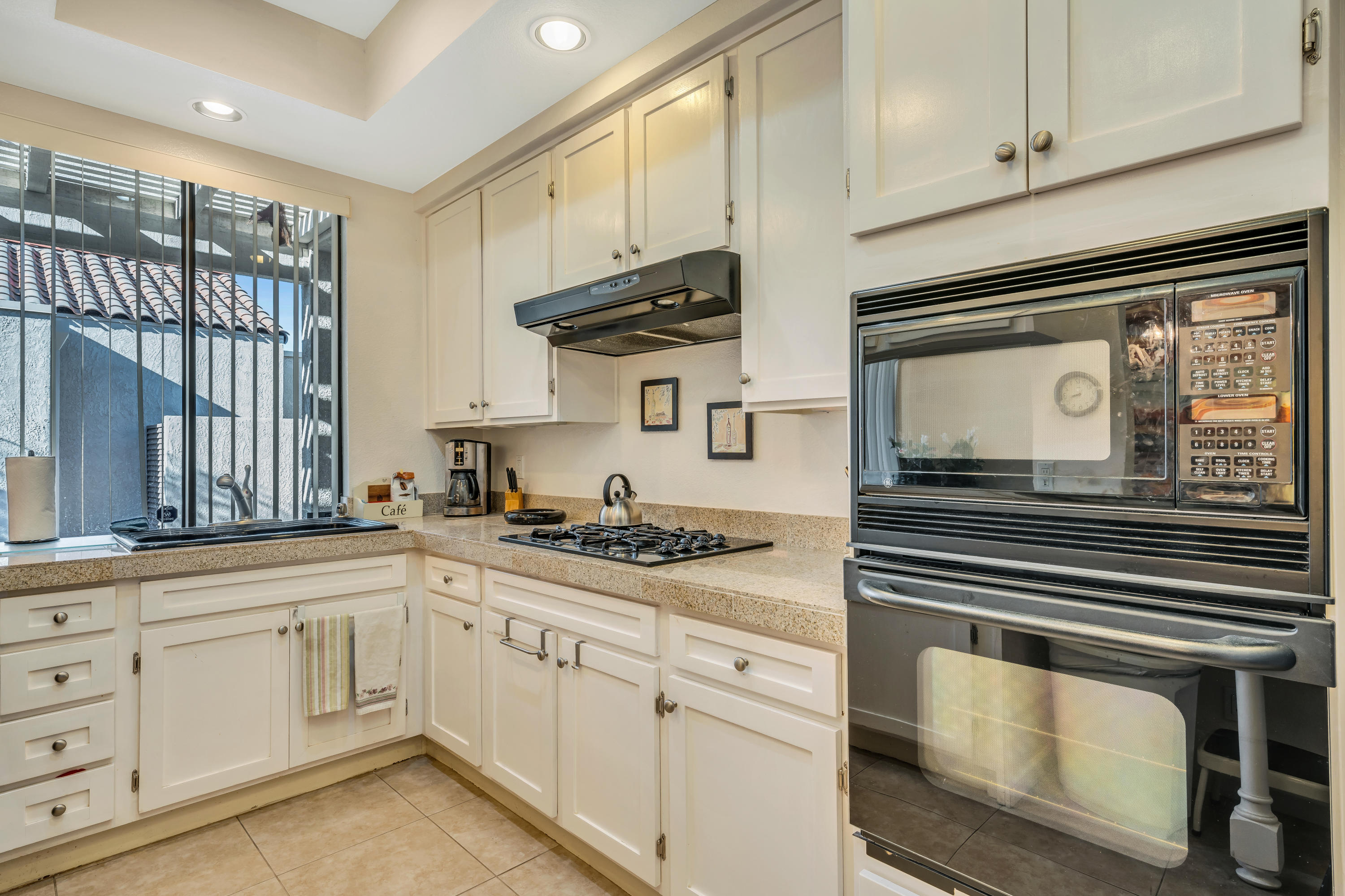 825 Inverness Drive Rancho Mirage, CA 92270 - Photo 19 of 34 a kitchen with white cabinets and appliances