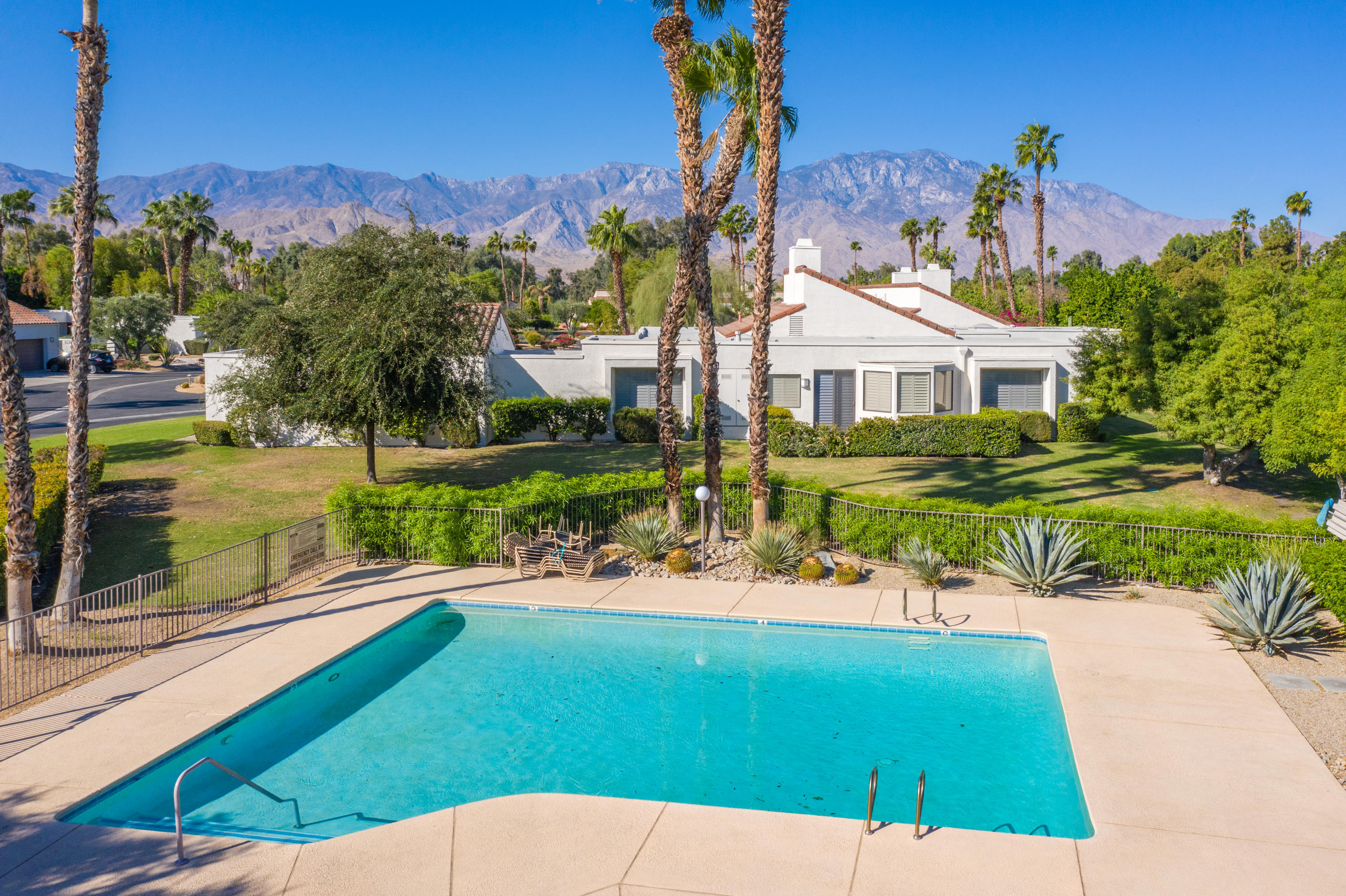 825 Inverness Drive Rancho Mirage, CA 92270 - Photo 27 of 34 a view of a house with a yard and table and chairs under an umbrella