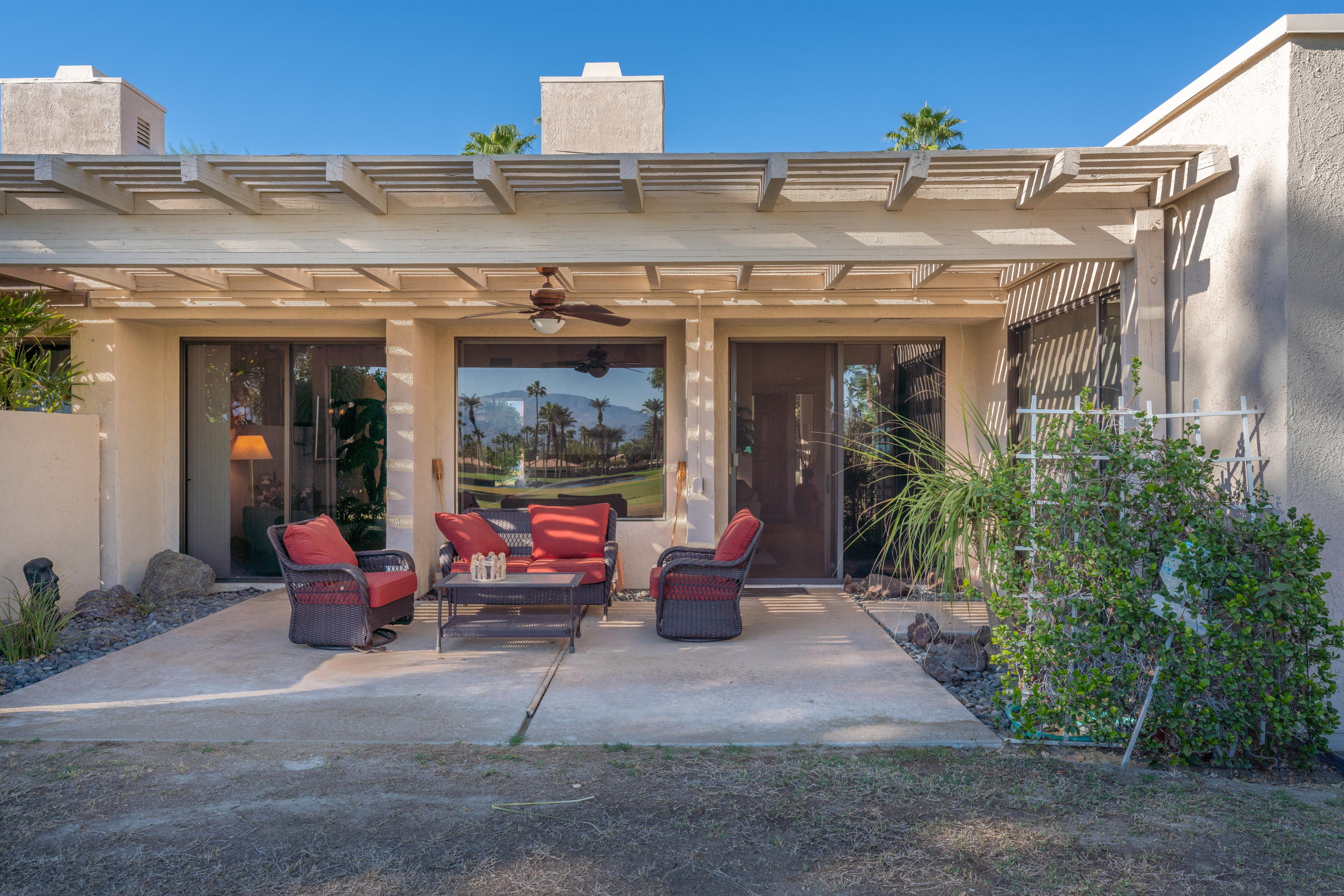 825 Inverness Drive Rancho Mirage, CA 92270 - Photo 8 of 34 a view of a patio with dining table and chairs under an umbrella
