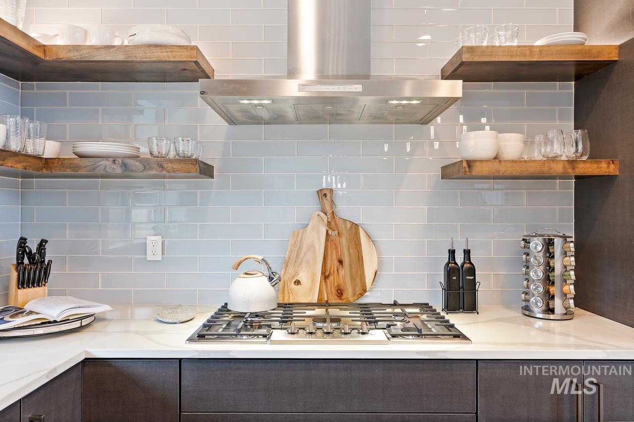 599 West Warren Street Boise, ID 83706 - Photo 15 of 41 Kitchen featuring a gas cooktop, stainless steel range hood, white countertop, light blue subway tile backsplash, and dark wood-finish cabinetry with open shelving