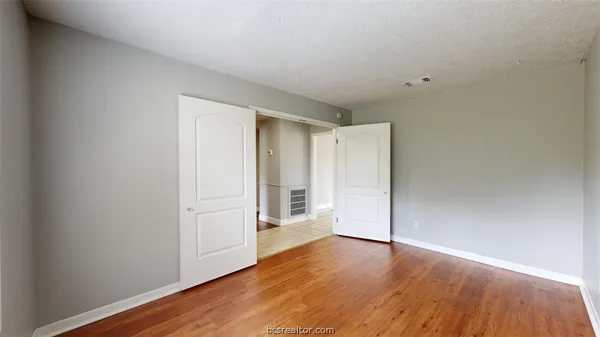 a view of a room with wooden floor