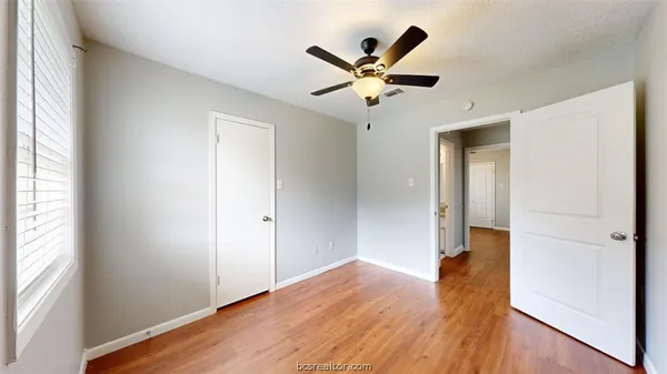 a view of a hallway with wooden floor and a window