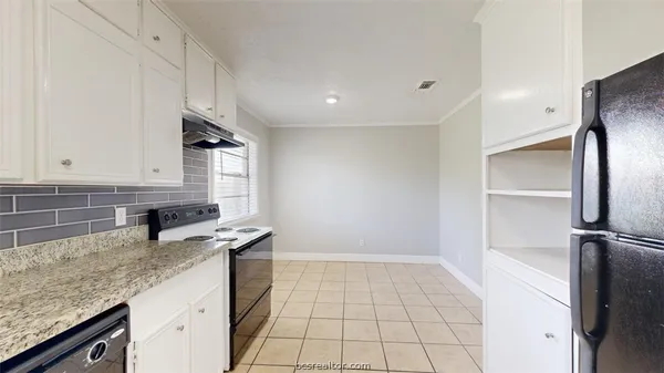 a kitchen with granite countertop a sink stainless steel appliances and white cabinets