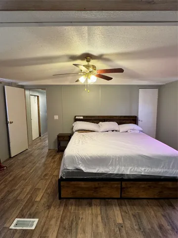 a bedroom with a bed and wooden floor