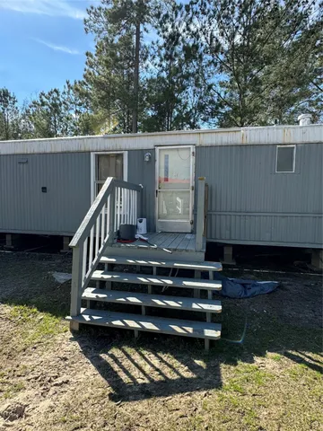 a view of backyard with wooden fence and large trees