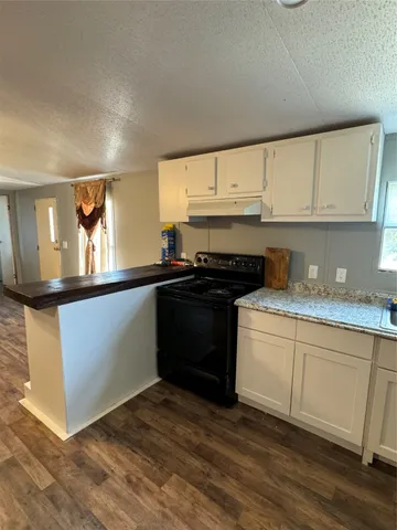 a kitchen with granite countertop a sink and a stove top oven