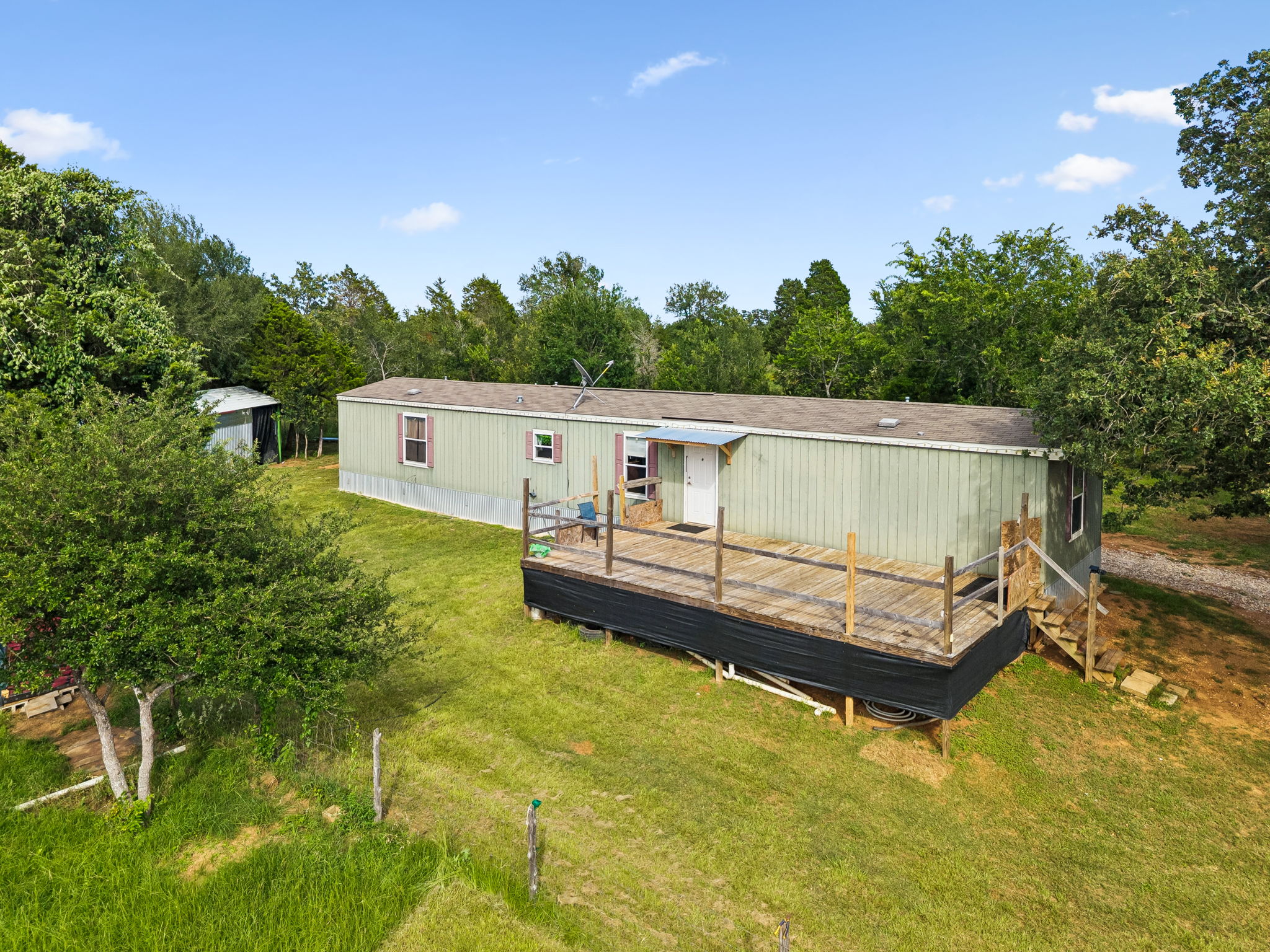 A spacious wood deck extends from this verdant, nature-immersed residence.