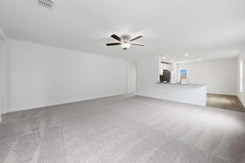 an empty room with a ceiling fan and a window