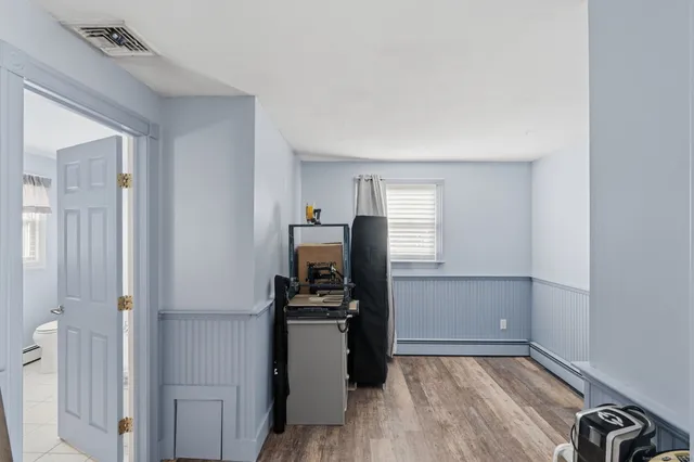 a view of kitchen with refrigerator cabinets and wooden floor