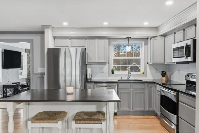 a kitchen with stainless steel appliances granite countertop a refrigerator and a stove top oven