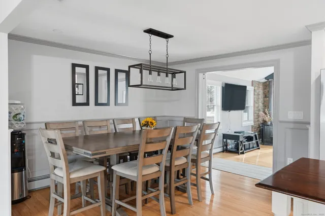 a dining room with furniture a chandelier and wooden floor