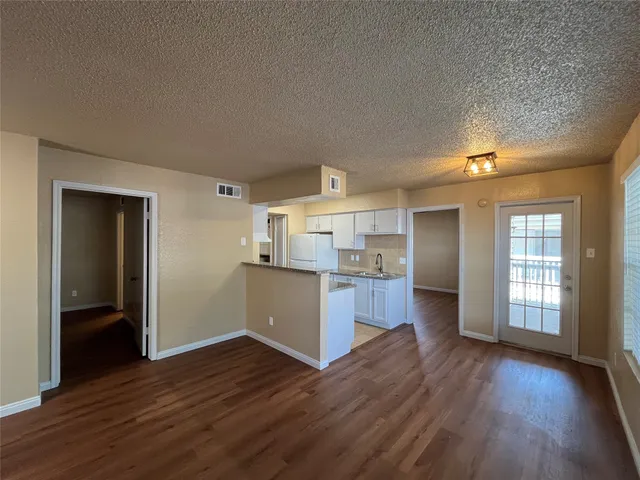 a kitchen with wooden floors and refrigerator