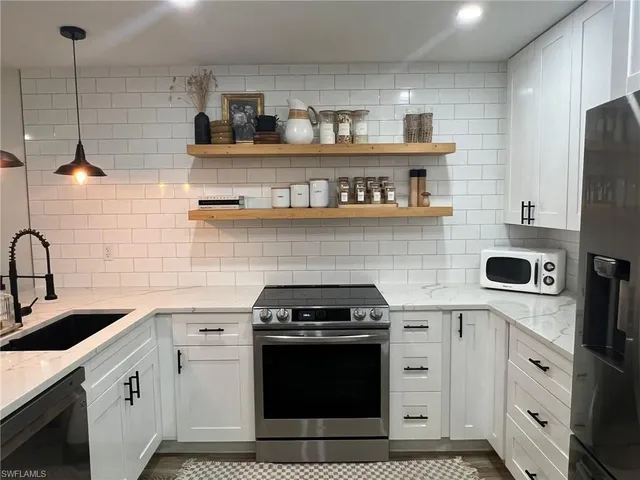 a kitchen with appliances a sink and cabinets