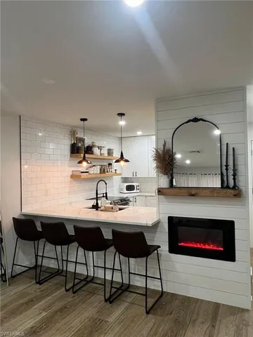 a kitchen with furniture wooden floor and a fireplace
