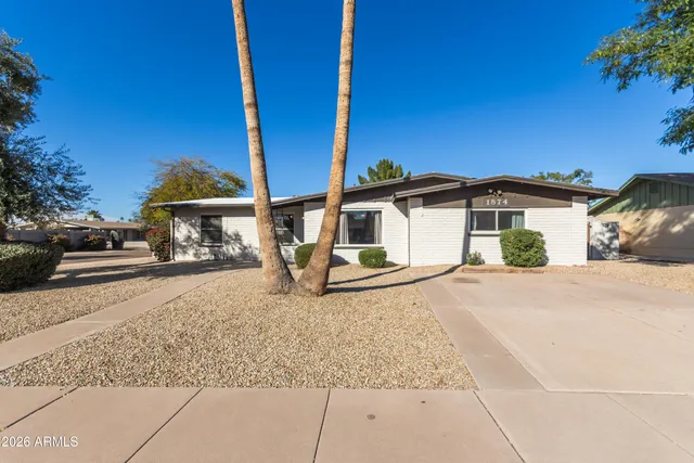 a view of a house with a yard and large tree