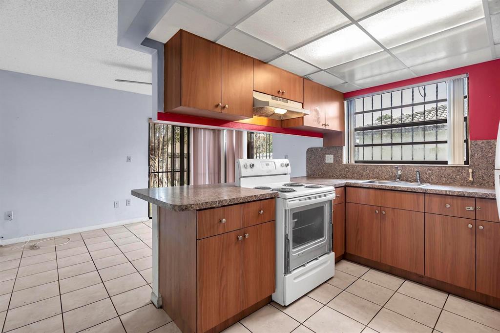 602 Southwest 99th Place Miami, FL 33174 - Photo 12 of 42 a kitchen with stainless steel appliances granite countertop a stove a sink and a microwave