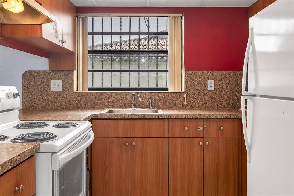 602 Southwest 99th Place Miami, FL 33174 - Photo 14 of 42 a kitchen with a sink stove and cabinets