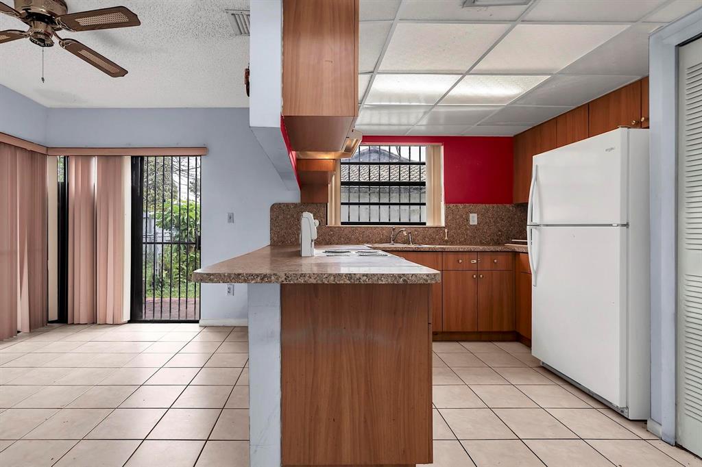602 Southwest 99th Place Miami, FL 33174 - Photo 15 of 42 a kitchen with a refrigerator a stove top oven a sink and a window