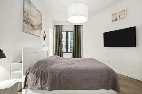 a bedroom with a bed and a flat screen tv