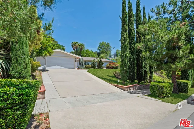 a view of a house with a yard and potted plants