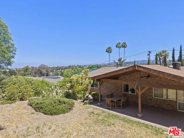 a view of a patio with a table and chairs under an umbrella