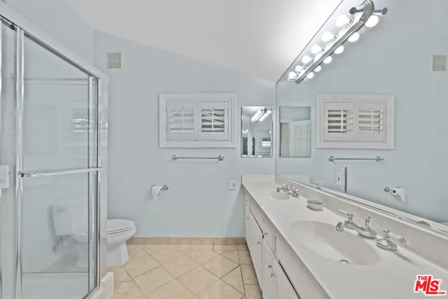 a bathroom with a double vanity sink toilet and shower