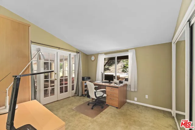 a view of a workspace with furniture and a window