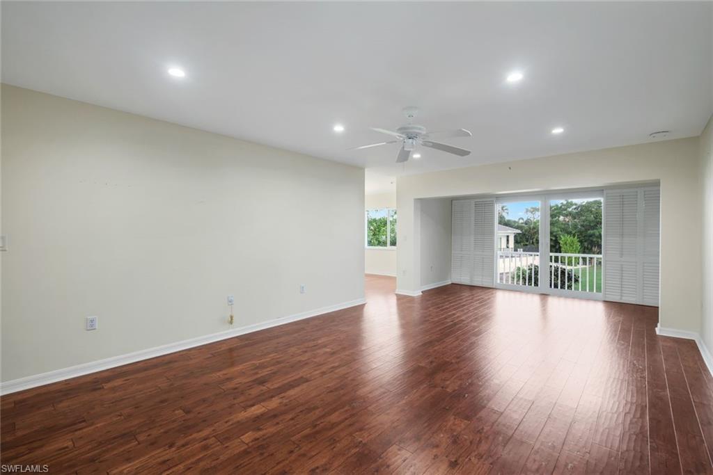 4160 Crayton Road, Unit A8 Naples, FL 34103 - Photo 12 of 26 an empty room with wooden floor and windows