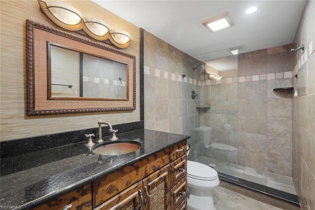 4160 Crayton Road, Unit A8 Naples, FL 34103 - Photo 20 of 26 a bathroom with a granite countertop sink toilet and shower