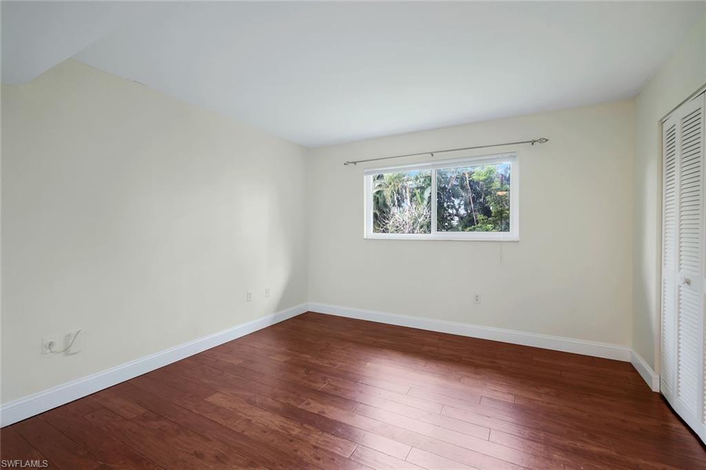 4160 Crayton Road, Unit A8 Naples, FL 34103 - Photo 22 of 26 an empty room with wooden floor and window