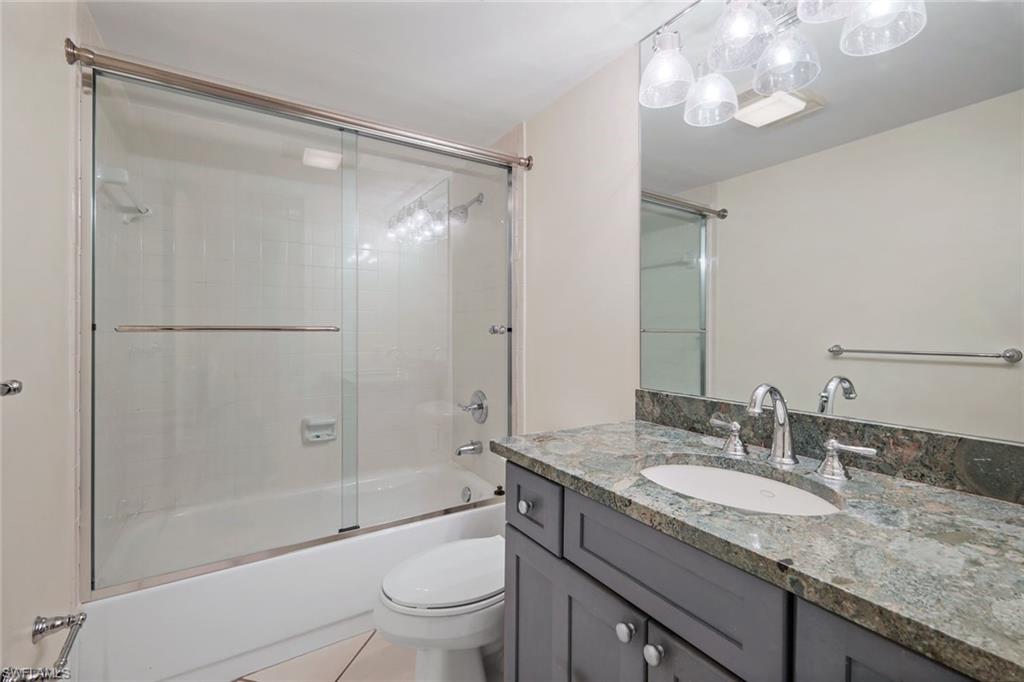 4160 Crayton Road, Unit A8 Naples, FL 34103 - Photo 23 of 26 a bathroom with a granite countertop sink a toilet and shower